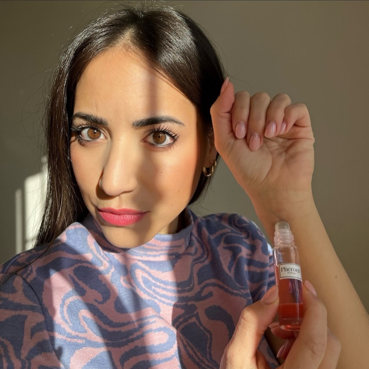 Vrouw brengt Pheroeli parfum aan op haar pols
